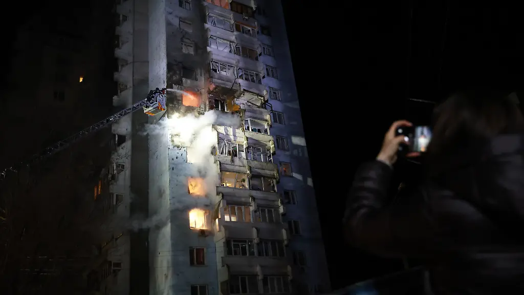 Rettungskraefte-versuchen-ein-Feuer-in-einem-Wohnhaus-zu-loeschen-das-nach-einem-russischen-Drohnenangriff-brennt