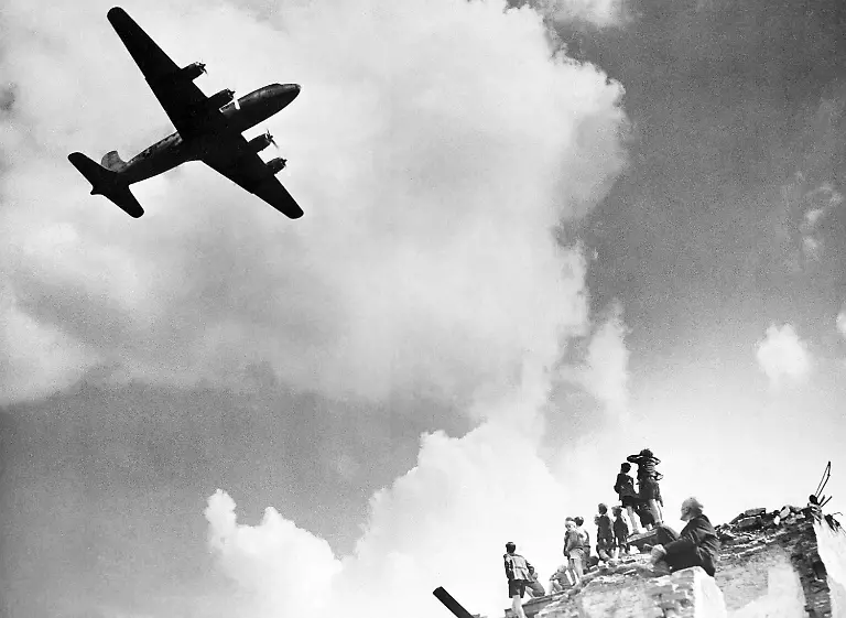 Berliners-young-and-old-cluster-atop-ruins-of-a-bombed-out-building-to-watch-the-arrival-of-a-U-S-C-54-cargo-plane-at-the-Tempelhof-Airport-during-the-Berlin-blockade-of-1948