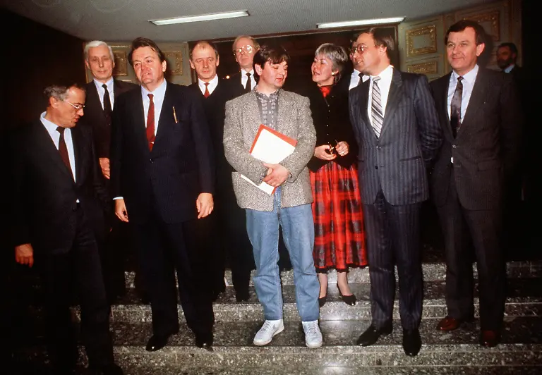 ARCHIV-Die-neue-hessische-Landesregierung-stellt-sich-am-12-12-1985-den-Fotografen-zum-Gruppenbild-nachdem-der-hessische-Landtag-in-Wiesbaden-mit-den-Stimmen-von-SPD-und-Gruenen-der-Landesregierung-und-Ministerpraesident-Holger-Boerner-SPD-3-v-l-das-Vertrauen-ausgesprochen-hat-Joschka-Fischer-M-wurde-als-erster-gruener-Umwelt-und-Energieminister-in-der-Bundesrepublik-vereidigt-ganz-leger-in-Turnschuhen-Foto-Joerg-Schmitt-dpa-lhe-zu-lhe-Korr-Dachlatten-Turnschuhe-und-eine-Atomfabrik-vom-14-10