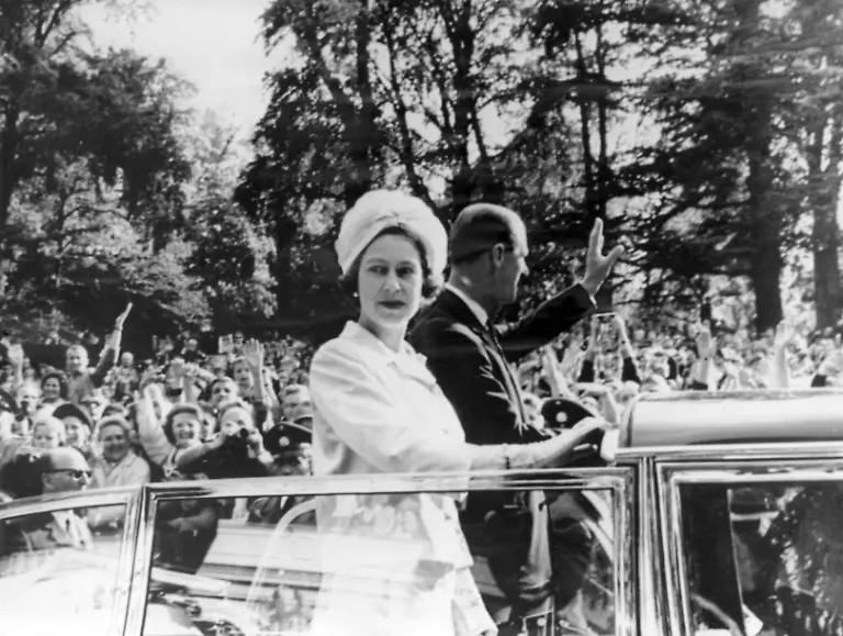 Koenigin-Elizabeth-II-und-Prinz-Philip-bei-ihrer-Fahrt-in-einem-offenen-Wagen-durch-die-Innenstadt-von-Bonn-am-19-05-1965-Am-Strassenrand-jubeln-und-winken-Menschen-dem-Koenigspaar-zu-Die-britische-Monarchin-haelt-sich-vom-18-bis-28-Mai-1965-zu-ihrem-ersten-Staatsbesuch-in-Deutschland-auf