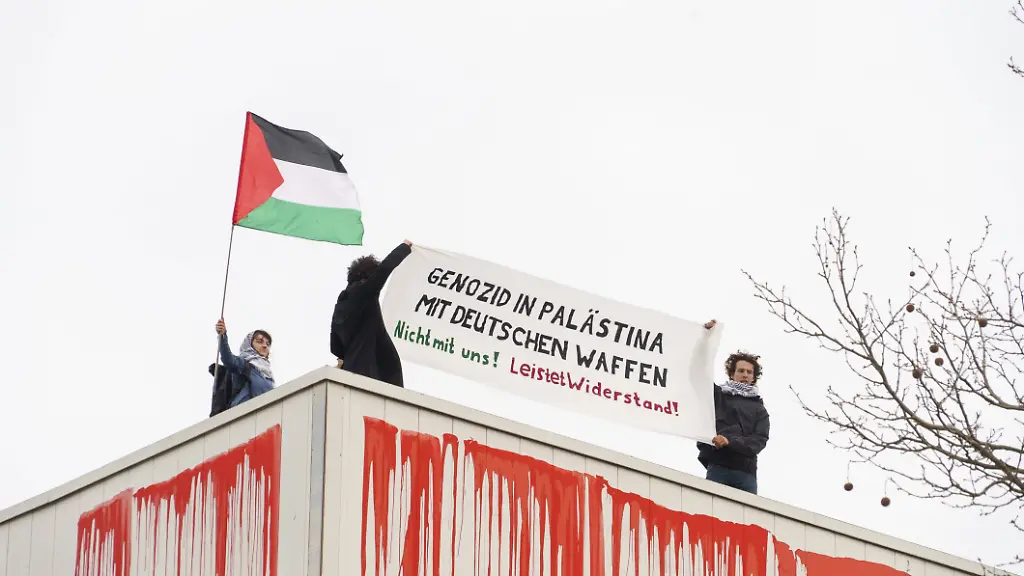Protest-at-Rheinmetall-premises-against-military-production-in-Berlin-BERLIN-GERMANY-MARCH-25-Activists-from-Peacefully-Against-Genocide-stage-a-protest-at-the-Berlin-premises-of-Rheinmetall-a-major-German-defense-and-automotive-technology-company-specializing-in-military-vehicles-weapons-systems-and-ammunition-on-March-25-2026-Protesters-climbed-onto-the-roof-to-display-Palestinian-flags-and-banners-and-poured-red-paint-down-the-building-Ilkin-Eskipehlivan-Anadolu-Berlin-Germany-Editorial-use-only-Please-get-in-touch-for-any-other-usage