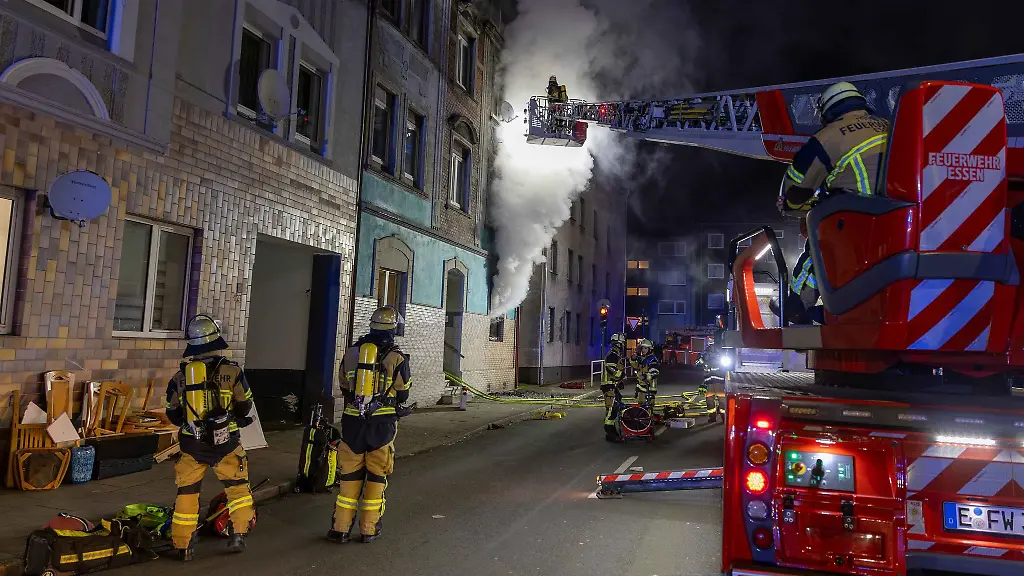 Feuerwehrleute-loeschen-den-Brand-in-dem-Mehrfamilienhaus