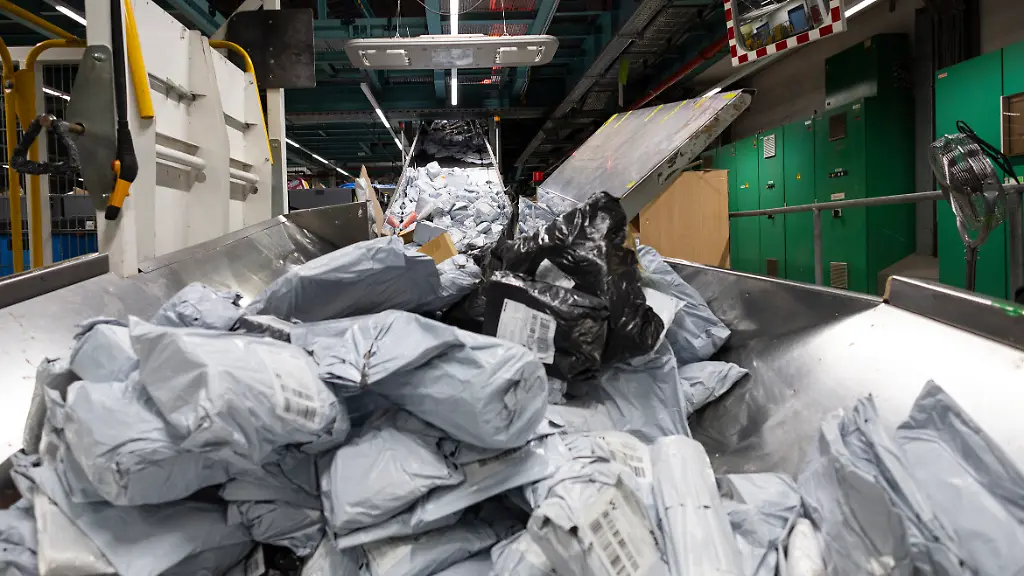 Ein-Berg-an-Postsendungen-liegt-auf-einem-Foerderband
