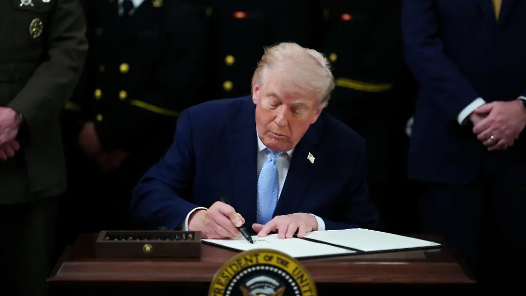 US-Praesident-Donald-Trump-unterzeichnet-eine-Durchfuehrungsverordnung-waehrend-einer-Veranstaltung-zur-Verleihung-der-Commander-in-Chief-s-Trophy-mit-dem-Navy-Midshipmen-Football-Team-im-East-Room-des-Weissen-Hauses