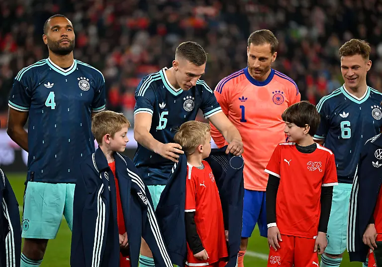 27-03-2026-Fussball-Freundschafts-Laenderspiel-Schweiz-Deutschland-im-Stadion-St-Jakob-Park-in-Basel-Schweiz-Suesse-Geste-die-Nationalspieler-geben-den-Einlaufkindern-die-Jacken-v-l