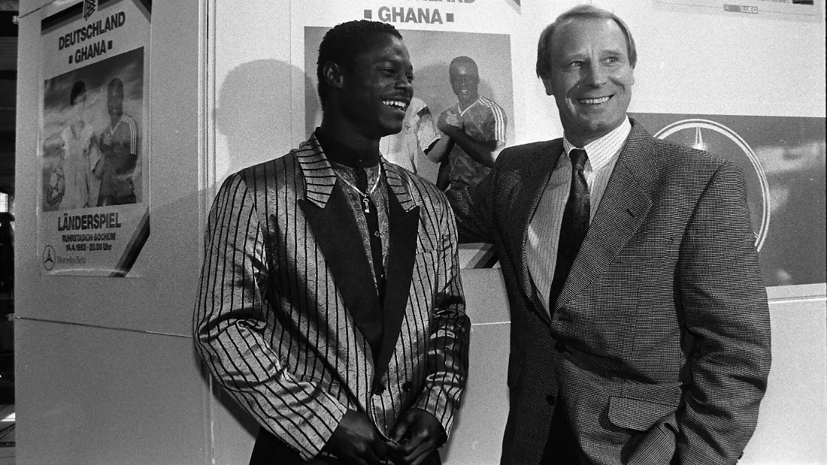 firo-Fussball-Fussball-Deutschland-Ghana-14-4-1993-Berti-Vogts-mit-Anthony-Yeboah-vor-dem-Spielankuendigungsplakat-Das-Laenderspiel-fand-in-Bochum-statt