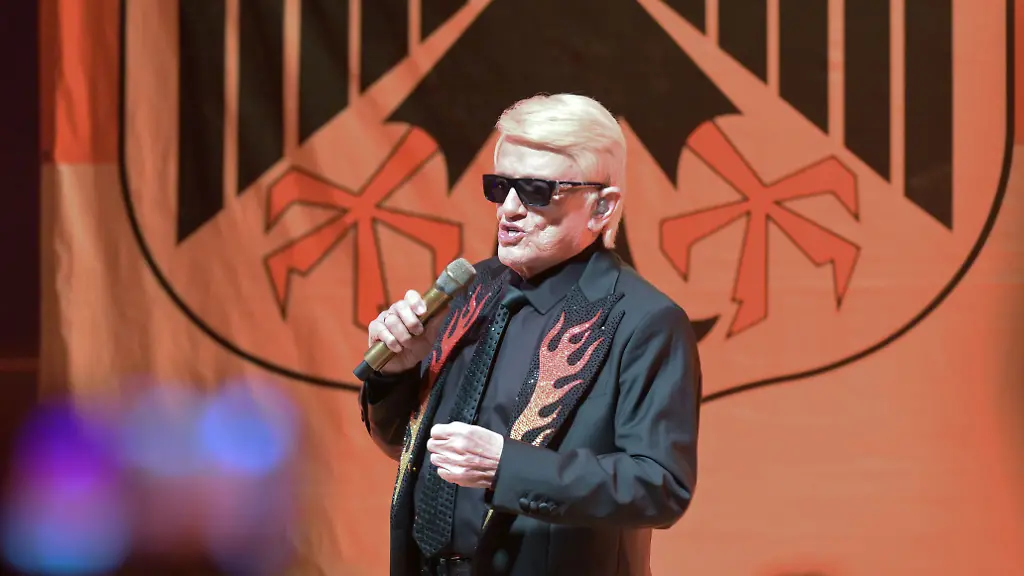 Schlagersaenger-Heino-singt-im-Rahmen-eines-Zusatzkonzert-in-der-Bad-Belziger-Albert-Baur-Halle-Hintergrund-ist-ein-Vorfall-bei-den-Deutschen-Feuerwehrmeisterschaften-im-August-in-Torgau-wo-bei-der-Eroeffnungsfeier-die-von-Heino-gesungene-Version-des-Lieds-der-Deutschen-abgespielt-wurde-mit-allen-drei-Strophen-darunter-die-auch-die-erste-Ein-Feuerwehrmann-aus-Bad-Belzig-war-daraufhin-von-seinen-Aemtern-ausgeschlossen-worden