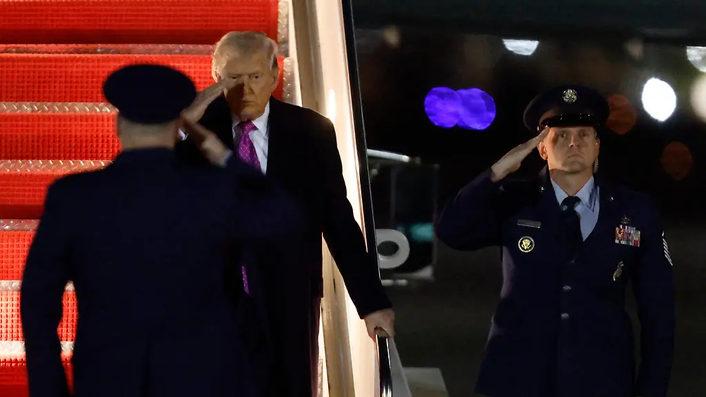 President-Donald-Trump-center-is-greeted-by-Air-Force-Col-Christopher-M-Robinson-commander-89th-Airlift-Wing-left-after-walking-down-the-stairs-of-Air-Force-One-upon-his-arrival-at-Joint-Base-Andrews-Md-Sunday-March-29-2026-after-visiting-his-Mar-a-Lago-estate-in-Palm-Beach-Fla-AP-Photo-Luis-M