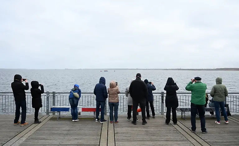 Schaulustige-verfolgen-die-Rettungsarbeiten-fuer-einen-Wal-in-der-Ostsee-Der-vor-rund-einer-Woche-bei-Timmendorfer-Strand-an-der-Ostseekueste-gestrandete-Wal-liegt-aktuell-vor-Wismar