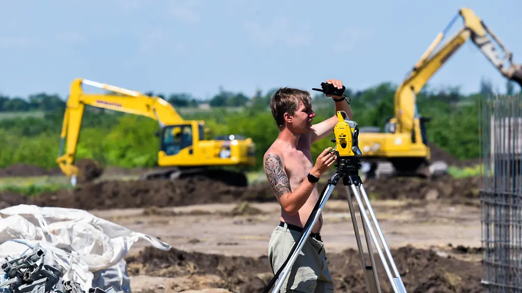 DIESES-FOTO-WIRD-VON-DER-RUSSISCHEN-STAATSAGENTUR-TASS-ZUR-VERFUeGUNG-GESTELLT-DONETSK-REGION-UKRAINE-JUNE-18-2022-A-geodetic-surveyor-is-at-work-at-the-construction-site-of-a-new-neighborhood-in-the-city-of-Mariupol-Specialists-of-the-Russian-Defense-Ministry-started-building-a-residential-neighborhood-at-the-site-of-the-former-Azovsky-market-Twelve-5-storey-buildings-and-an-outpatient-clinic-will-be-completed-within-6-months-Fifty-pieces-of-construction-equipment-have-been-delivered-to-the-construction-site-First-temporary-houses-with-all-the-modern-amenities-will-be-completed-in-Mariupol-in-June