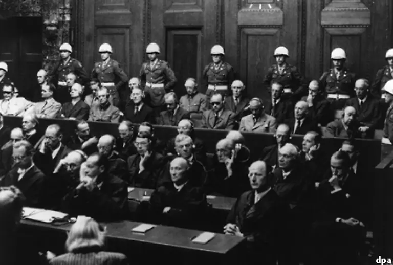 Insgesamt-21-Mitglieder-des-Obersten-Kommandos-der-Wehrmacht-mussten-sich-fuer-ihre-Taten-vor-dem-internationalen-Militaertribunal-verantworten-Vorletzte-Reihe-v-l-Goering-Hess-von-Ribbentrop-Keitel-Kaltenbrunner-Rosenberg-Franck-Frick-Streicher-und-Funk-Hintere-Reihe-Doenitz-Raeder-von-Schirach-Sauckel-Jodl-von-Papen-Seyss-Inquart-Speer-und-von-Neurath