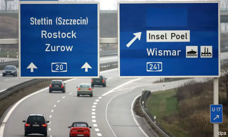 Zwar-kommen-Touristen-von-Westen-und-Sueden-jetzt-schneller-an-die-Ferienorte-der-Ostsee-und-auf-die-Ostseeinseln-Ruegen-Usedom-und-auf-den-Darss-Doch-die-endgueltige-Fertigstellung-der-Strecke-ist-laengst-nicht-fuer-alle-Menschen-ein-Anlass-zum-Feiern-Denn-die-Enstehungsgeschichte-ist-in-den-Augen-der-A-20-Gegner-auch-eine-Geschichte-voll-fauler-Kompromisse-und-gescheiterter-Proteste
