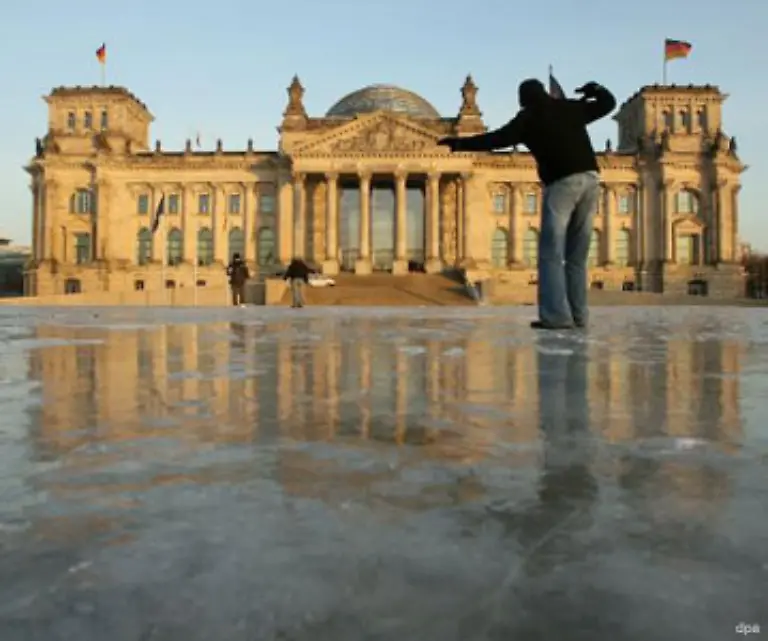Die-Deutschen-leiden-unter-der-extremen-Kaelte-mit-zweistelligen-Minusgraden-Dieser-englische-Tourist-schlittert-ueber-die-gefrorene-Wiese-vor-dem-Berliner-Reichstag