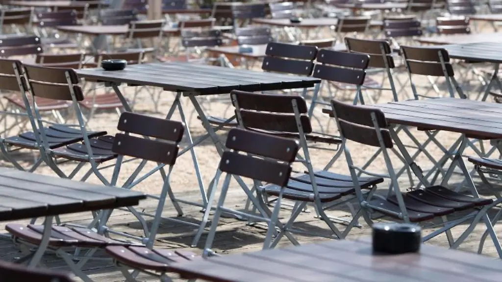 Leere-Tische-und-Stuehle-stehen-in-einem-Biergarten