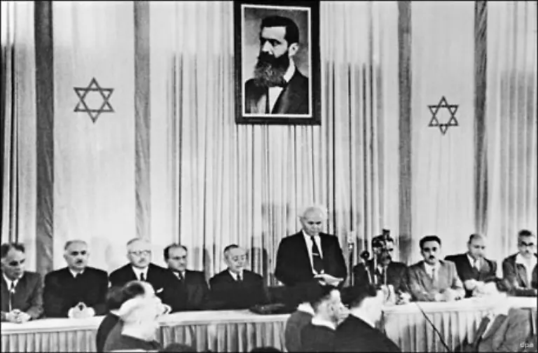 Erster-Regierungschef-war-David-Ben-Gurion-Er-gehoerte-der-Mapai-Partei-einer-zionistisch-sozialistischen-Arbeitspartei-an-Auf-diesem-Foto-verkuendet-Ben-Gurion-vor-Mitgliedern-der-juedischen-Ratsversammlung-die-Gruendung-des-Staates-Israel