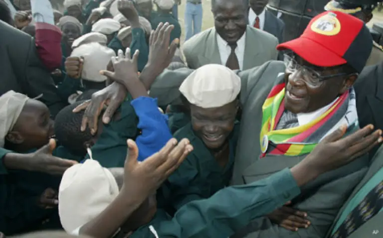 Mugabe-mit-seinen-Anhaengern-Der-mittlerweile-82-Jaehrige-trieb-das-Land-in-den-oekonomischen-Ruin-Die-Agrarproduktion-sank-durch-Sperrung-westlicher-Bankkredite-Misswirtschaft-und-Zerstoerungen-durch-die-schwarzen-Besetzer-immens-Es-kam-in-Simbabwe-sogar-zu-Hungersnoeten