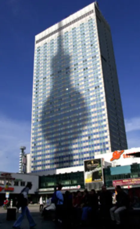 Weithin-sichtbar-ist-der-Berliner-Fernsehturm-Das-mit-368-Metern-hoechste-Bauwerk-Deutschlands-begrenzt-den-Alex-auf-der-westlichen-Seite-In-der-Kugel-befinden-sich-eine-Aussichtsplattform-und-ein-Restaurant-Ihm-gegenueber-steht-auf-der-Ostseite-das-Park-Inn-Hotel-das-zu-DDR-Zeiten-Hotel-Stadt-Berlin-hiess