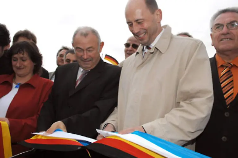 Irgendwo-wird-immer-eine-Autobahn-ein-Einkaufscenter-oder-ein-Schwimmbad-eroeffnet-Und-immer-gibt-es-ein-Baendchen-durchzuschneiden