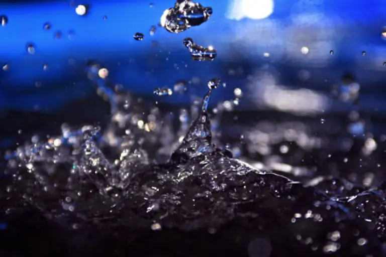 Wind-mit-mindestens-30-Kilometern-pro-Stunde-treibt-Schlagregen-aus-seiner-senkrechten-Fallrichtung-und-peitscht-ihn-schraeg-gegen-Haeuserwaende-und-unter-Schirme