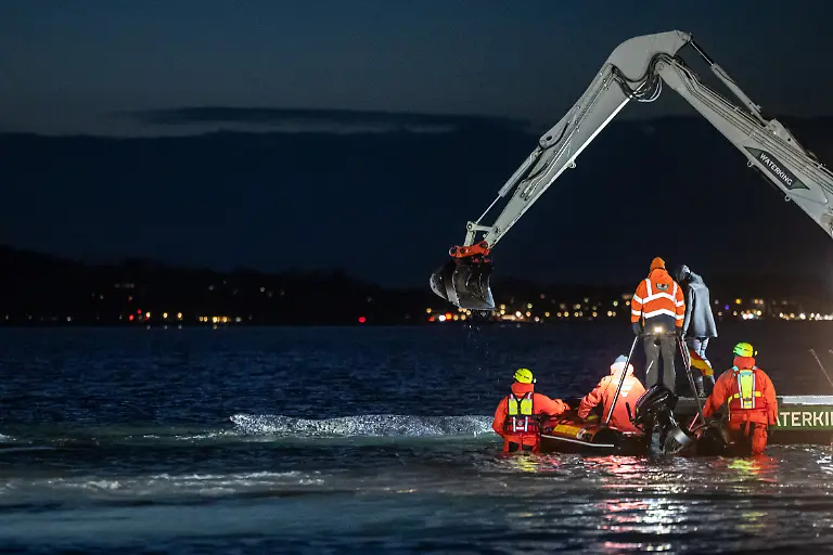 Ein-Helfer-weist-einen-Bagger-ein-Mehrere-Bagger-arbeiten-in-der-Naehe-von-einem-gestrandeten-Wal-Experten-versuchen-erneut-den-vor-Timmendorfer-Strand-festsitzenden-Buckelwal-freizubekommen