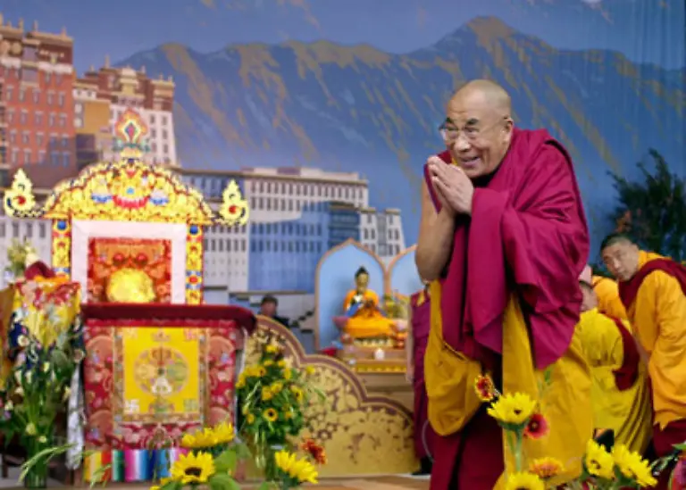 Das-Oberhaupt-der-Tibeter-lebt-seit-1959-nicht-mehr-in-seinem-Land-Die-tibetische-Szene-im-Hintergrund-ist-bloss-eine-Kulisse-im-Rahmen-eines-Vortrags-in-Kalifornien