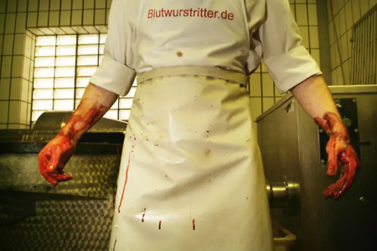 in-traditioneller-Handarbeit-seine-drei-Mal-als-Beste-Blutwurst-Europas-ausgezeichnete-schwarze-Wurst-her
