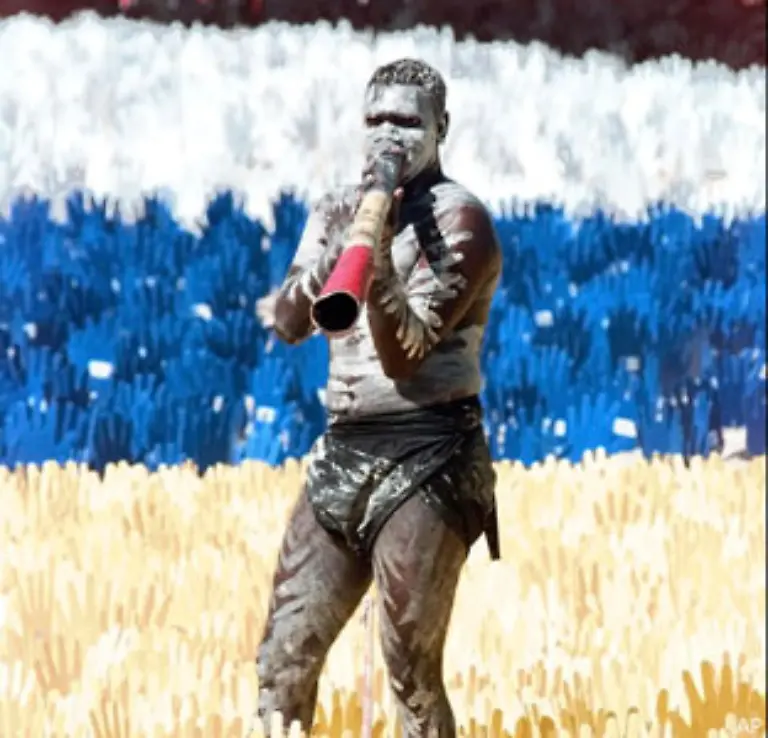 Das-Didgeridoo-dessen-Name-eine-Lautmalerei-des-von-ihm-erzeugten-Tones-ist-begleitet-die-traditionellen-Gesaenge-und-Taenze-Es-wird-neuerdings-aber-auch-bei-modernen-Popgruppen-eingesetzt