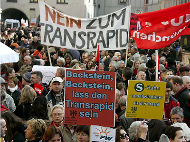 entwickelt-sich-breiter-Widerstand-in-der-Bevoelkerung-Im-Dezember-2007-legen-Transrapid-Gegner-dem-Land-mehr-als-38-000-Unterschriften-fuer-ein-Volksbegehren-gegen-die-Beteiligung-Bayerns