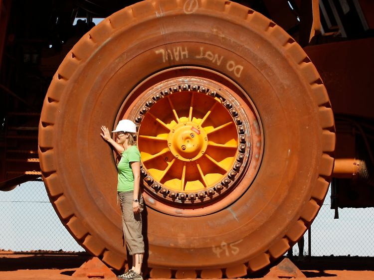 In einer Erzmine bei Tom Price in Westaustralien macht sich eine Touristin mit den Ausmaßen des Schürf-Equipments vertraut.