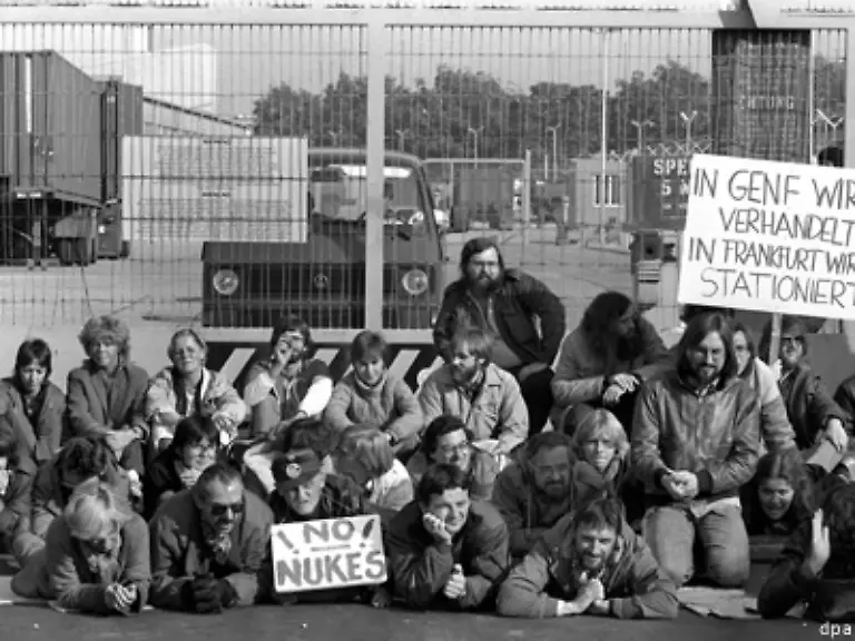 Er-ist-aber-auch-noch-auf-der-Strasse-zu-sehen-Mitglieder-der-Gruenen-Fischer-neben-dem-Schild-No-Nukes-blockieren-am-1983-ein-US-Militaergelaende-in-Frankfurt-das-nach-ihren-Informationen-fuer-die-Montage-von-Pershing-II-Raketen-vorgesehen-war