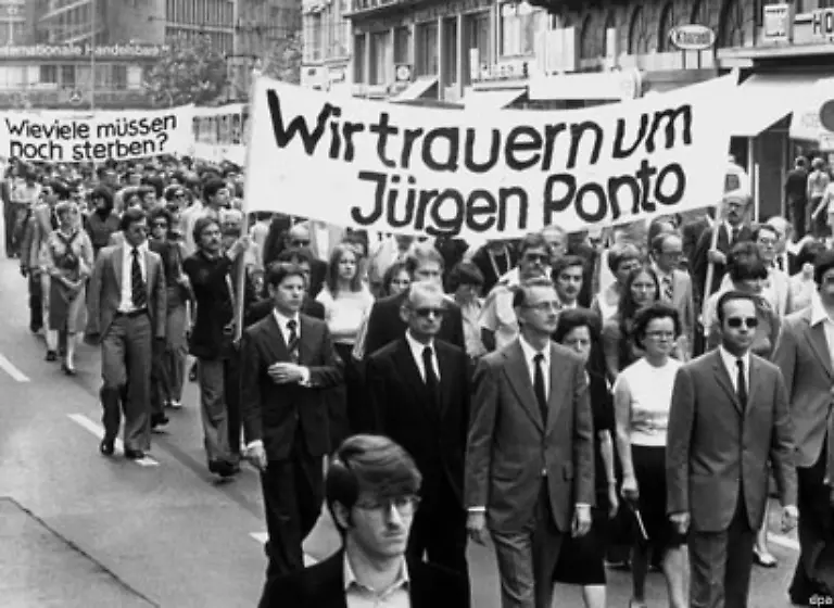 Die-Anonymitaet-der-dritten-RAF-Generation-hat-dazu-gefuehrt-dass-eine-Reihe-von-Verschwoerungstheorien-ueber-sie-aufbluehten-Im-Bild-Mit-einem-Schweigemarsch-in-Frankfurt-gedenken-1977-etwa-3000-Bankangestellte-des-ermordeten-Dresdner-Bank-Chefs-Juergen-Ponto