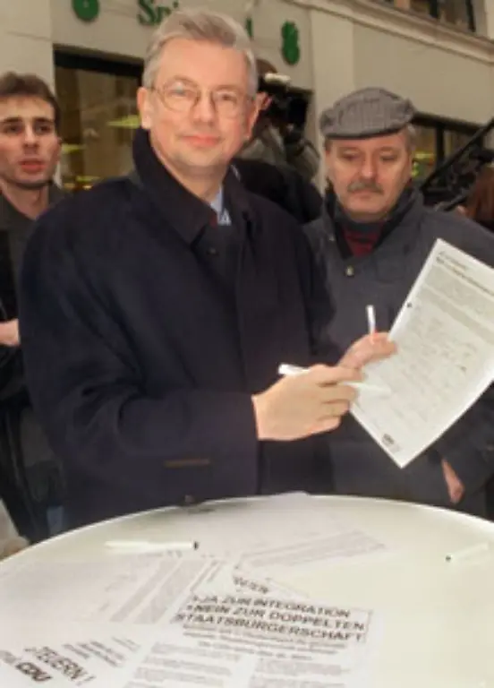 Gegen-das-Vorhaben-die-doppelte-Staatsbuergerschaft-zuzulassen-laeuft-die-Union-Sturm-Der-hessische-CDU-Wahlkaempfer-Roland-Koch-schwingt-sich-zur-treibenden-Kraft-einer-Unterschriftenaktion-seiner-Partei-gegen-das-Projekt-auf-und-gewinnt-im-Februar-1999-die-Wahl