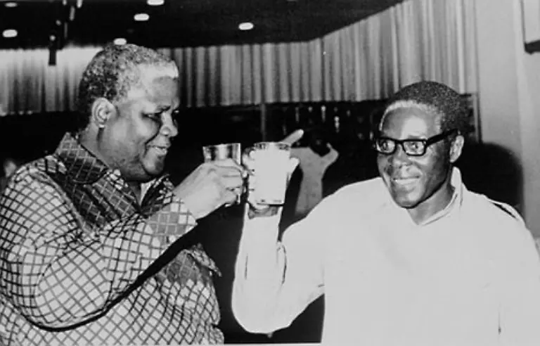 Nach-einer-weisser-Kolonialherrschaft-und-einer-von-Kaempfen-gepraegten-Uebergangszeit-erreicht-die-Guerillabewegung-um-Mugabe-und-seinen-Mitstreiter-Joshua-Nkomo-ihr-Ziel-Am-18-April-1980-wird-Simbabwe-unabhaengig