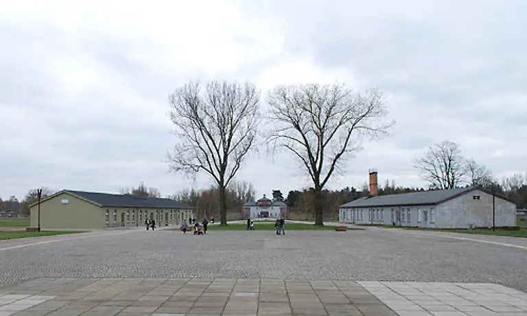 In-der-Mitte-des-ehemaligen-Lagers-stehen-noch-die-Baracken-der-Haeftlingskueche-links-und-die-ehemalige-Schreibstube-rechts-In-der-Haeftlingskueche-ist-die-neue-Ausstellung-zu-sehen