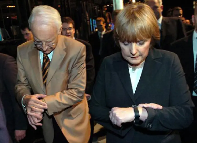 Synchron-aber-auch-zeitgleich-Nach-dem-69-CSU-Parteitag-am-19-November-2004-sehen-der-CSU-Vorsitzende-Edmund-Stoiber-und-die-CDU-Vorsitzende-Angela-Merkel-gemeinsam-auf-die-Uhr-jeder-auf-die-eigene-Oliver-Weiken-hat-s-gesehen