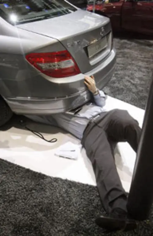 Auch-Uli-Deck-hat-beim-Autosalon-in-Genf-am-7-Maerz-2007-einen-Anzugtraeger-in-ungewoehnlicher-Pose-unter-einem-Mercedes-C-280-erwischt