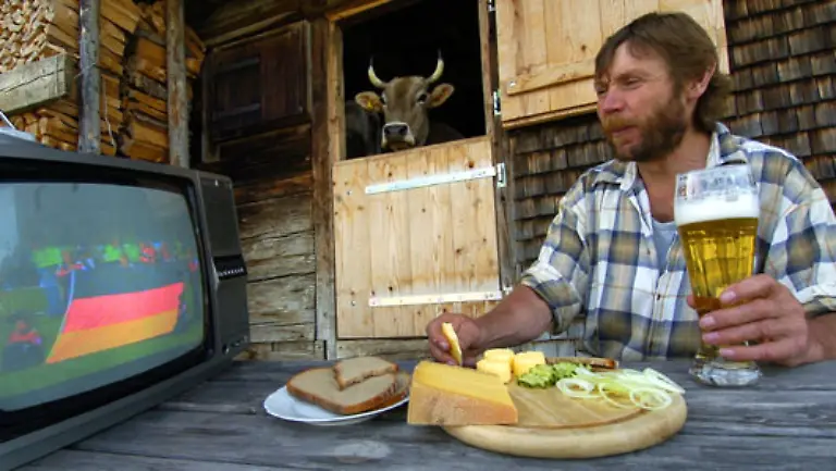 Und-wir-schalten-zurueck-zum-Fussball-und-kehren-mit-der-Erinnerung-ans-WM-Eroeffnungsspiel-am-9-Juni-2006-mit-Bauer-Berg-Kuh-Paula-und-Fotograf-Stefan-Puchner-den-Momentaufnahmen-der-Vergangenheit-den-Ruecken