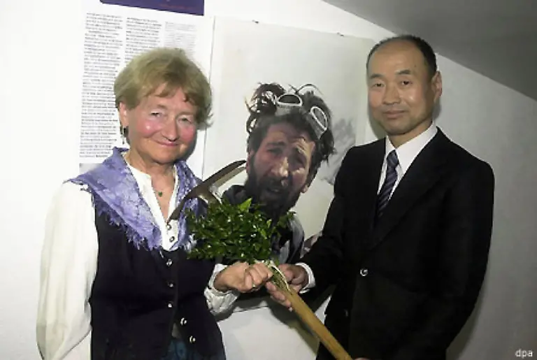 Der-erste-der-den-nackten-Berg-bezwang-so-nennen-ihn-die-Einheimischen-wegen-der-fast-eisfreien-Krone-war-der-Oesterreicher-Hermann-Buhl-1924-1957-am-3-Juli-1953-Ein-japanischer-Bergsteiger-uebergibt-Buhls-Eispickel-an-dessen-Witwe