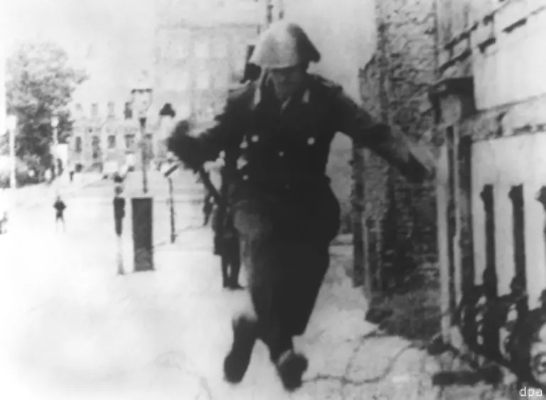 Bis-zum-September-1961-desertieren-allein-von-den-eingesetzten-Sicherungskraeften-85-Mann-nach-Westberlin-Das-Foto-des-jungen-Grenzpolizisten-Conrad-Schumann-beim-Sprung-ueber-den-Stacheldraht-an-der-Bernauer-Strasse-geht-um-die-Welt-Bild-15-August-1961