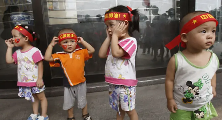 Unausgeschlafen-Go-China-steht-auf-den-Stirnbaendern-der-Kinder-nahe-dem-Tian-anmen-Platz