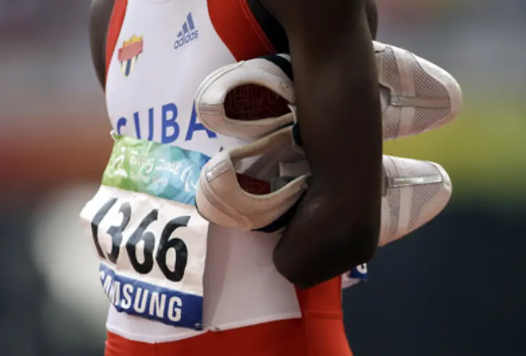 Ettiam-Calderon-aus-Kuba-klemmt-sich-nach-seinem-200-Meter-Lauf-die-Sportschuhe-unter-den-Arm