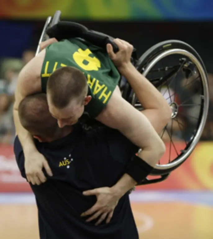 Basketballer-Michael-Hartnett-wird-von-seinem-australischen-Trainer-nach-dem-Turniersieg-hochgehoben