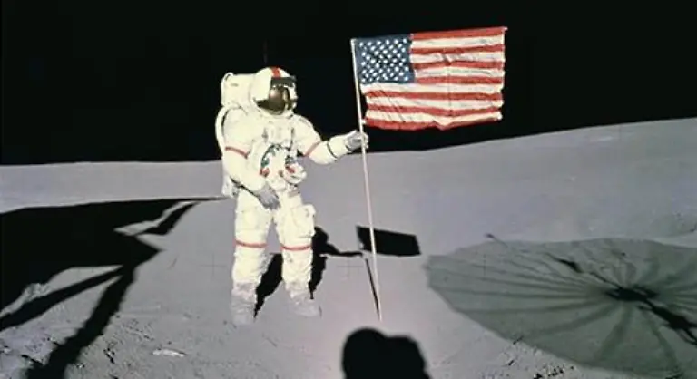 Die-Astronauten-in-ihren-unfoermigen-glaenzenden-Schutzanzuegen-vor-der-grauen-Mondlandschaft-die-Fussabdruecke-im-Mondstaub-das-Sternenbanner-auf-dem-Erdtrabanten