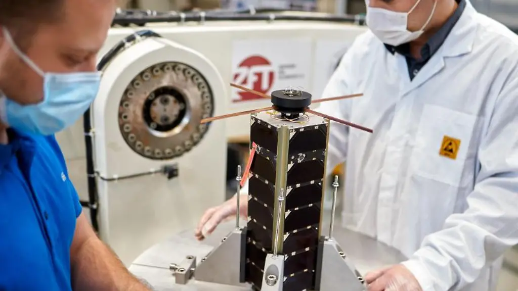 Zwei-Mitarbeiter-des-Zentrums-fuer-Telematik-bereiten-einen-NetSat-Satelliten-fuer-einen-Test-vor