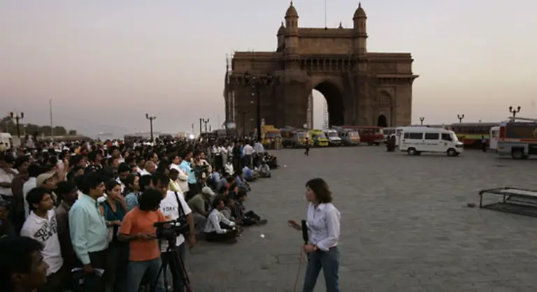 In-einem-oeffentlich-zugaenglichen-Hafen-den-Sassoon-Docks-steigen-sie-auf-ein-Schlauchboot-um-und-fahren-zum-Gateway-of-India-einem-Torbogen-aus-dem-Jahr-1924