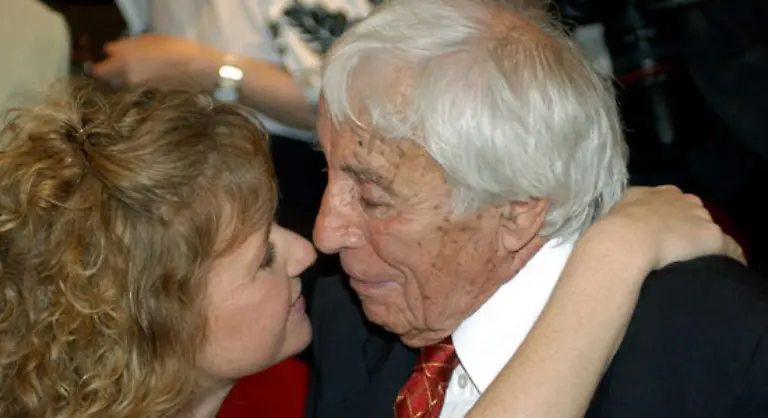 als-singender-Charmeur-alter-Schule-und-lebensfroher-Gigolo-mit-Frack-weissem-Seidenschal-Nelke-im-Knopfloch-und-dem-Champagnerglas-in-der-Hand