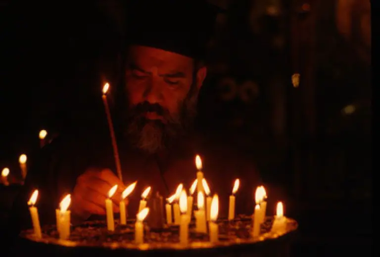 Ein-griechischer-Priester-prueft-den-Kerzenhalter