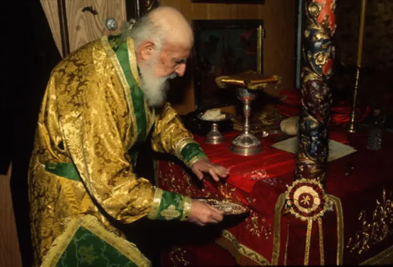 Ein-griechischer-Priester-befreit-den-Altar-von-Brotkruemeln-des-Abendmahlbrotes