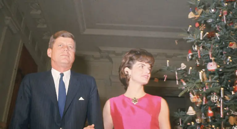 Praesident-John-F-Kennedy-und-First-Lady-Jacqueline-Kennedy-vor-dem-Weihnachtsbaum-in-der-Eingangshalle-des-Weissen-Hauses-Das-Bild-entstand-am-12-Dezember-1962-bei-einer-Feier-fuer-die-Angestellten