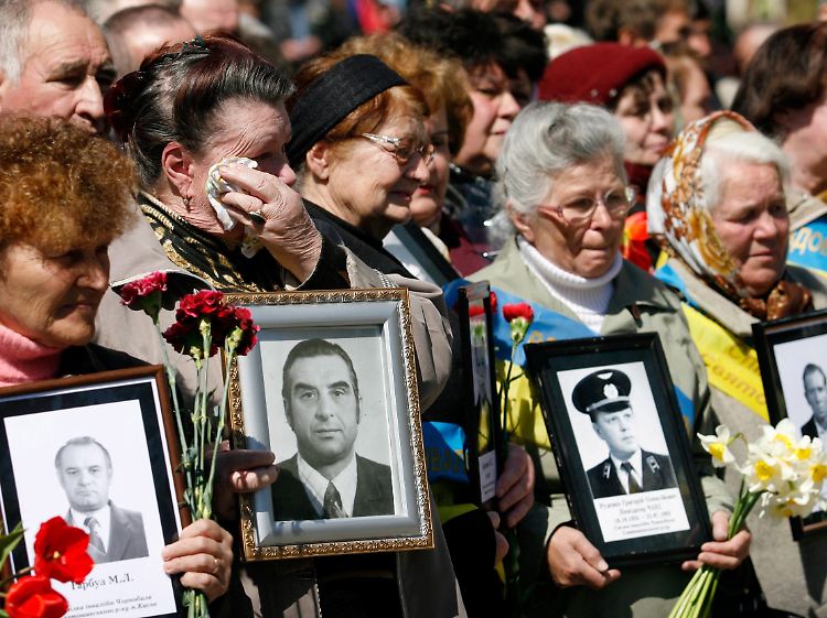 Frauen halten während einer Gedenkveranstaltung in Kiew Bilder ihrer Verwandten, die sie durch das Unglück in Tschernobyl verloren haben. (Archivbild vom 26.04.2010)